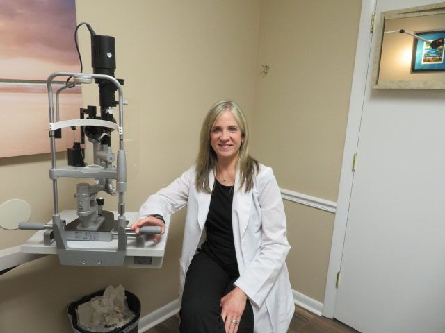 A woman sitting in front of an eye exam machine.